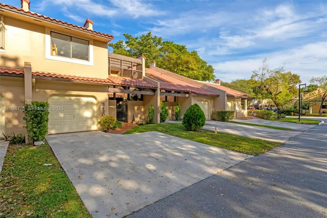 a view of a house with brick walls and a yard with plants