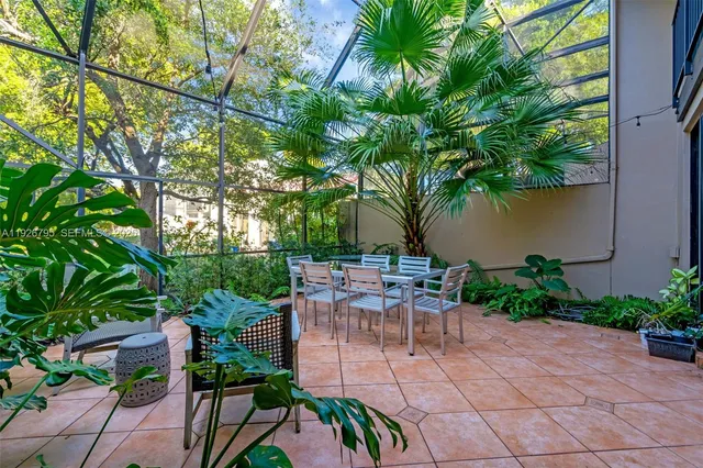 a view of backyard with outdoor seating and plants