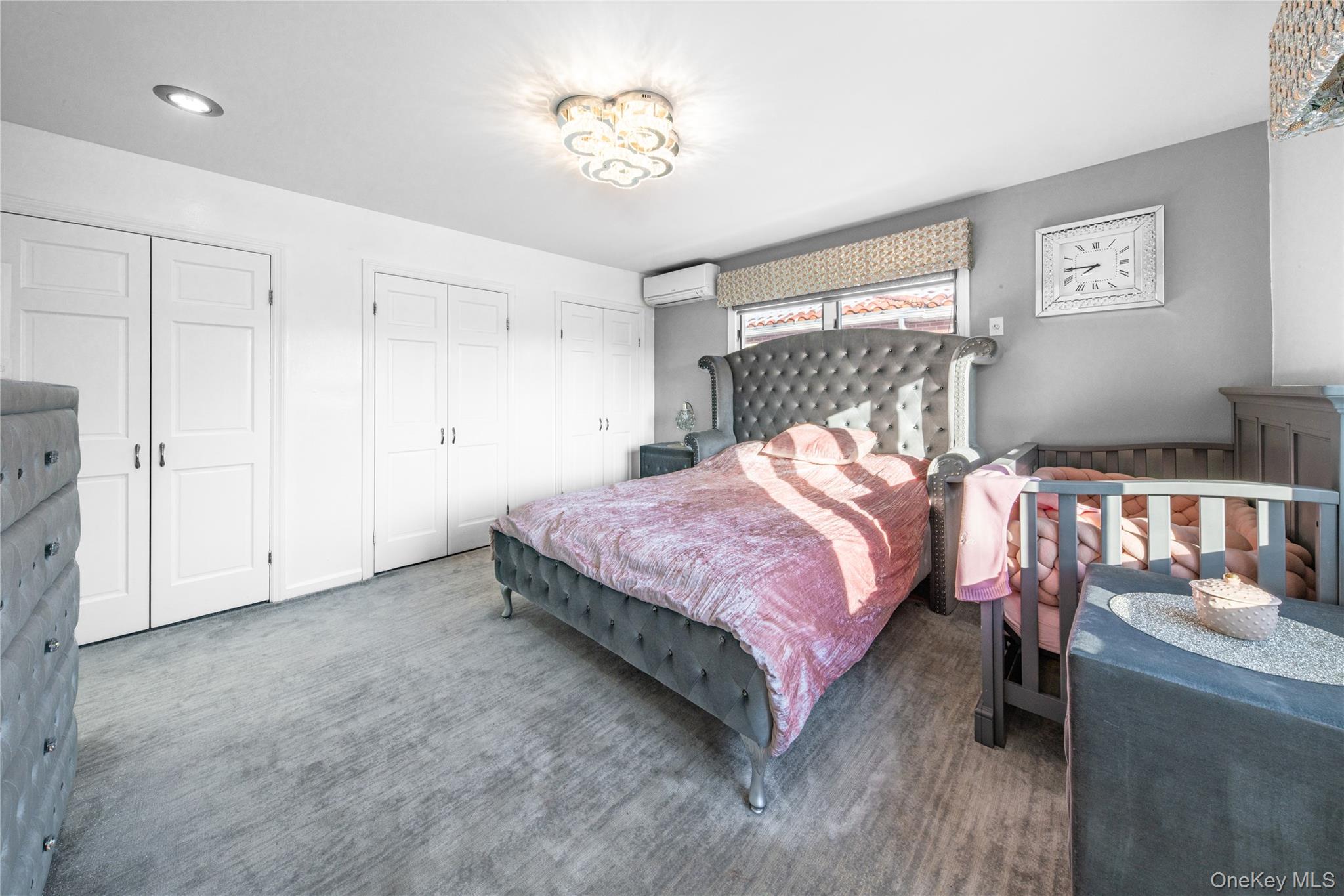 166-02 76th Avenue Queens, NY 11366 - Photo 14 of 28 a bedroom with a bed and a chandelier