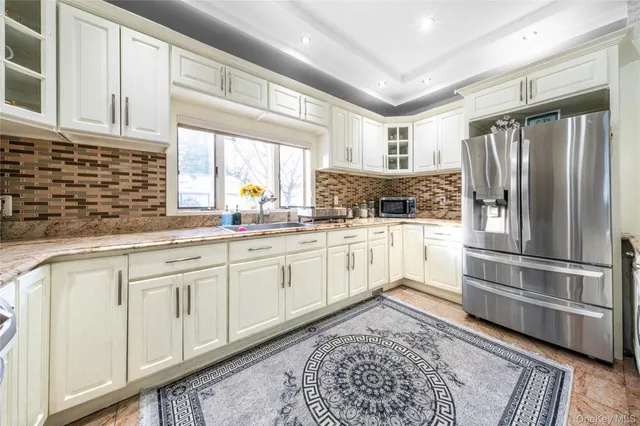 a kitchen with white cabinets and white appliances