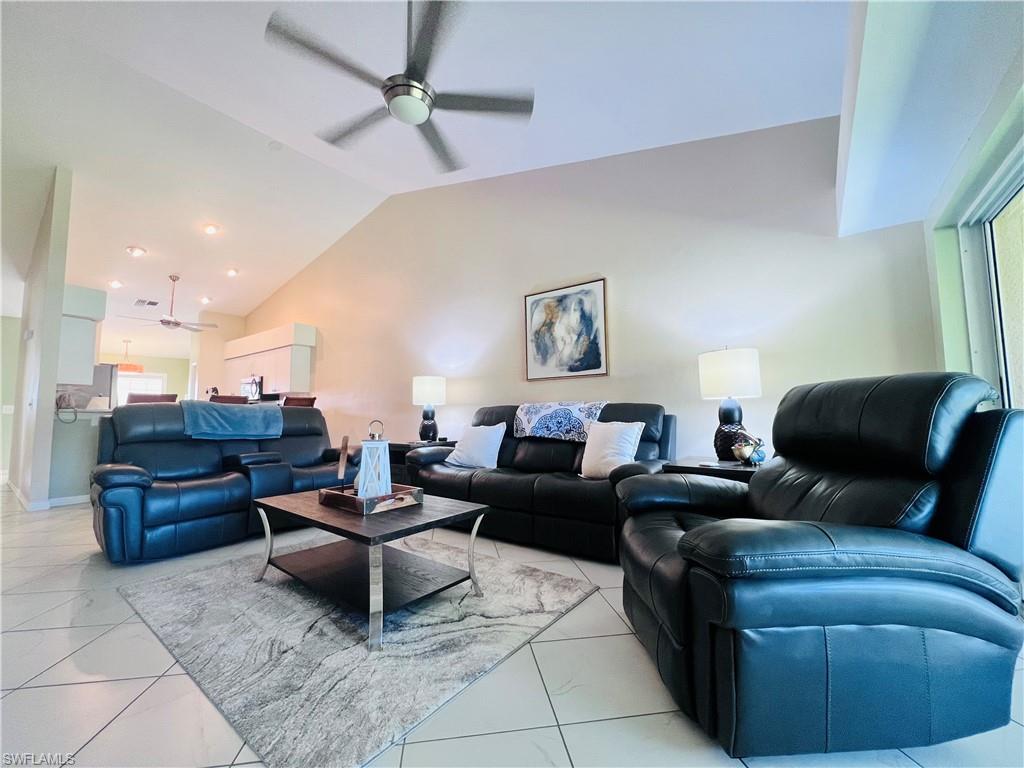 8073 Panther Trail, Unit 1404 Naples, FL 34113 - Photo 9 of 29 a living room with couches a fireplace and a kitchen view