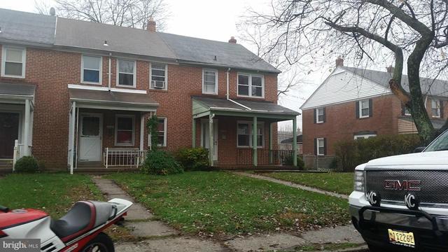 1215 Cedarcroft Road Baltimore, MD 21239 - Photo 1 of 11 a backyard of a house with table and chairs potted plants and large tree