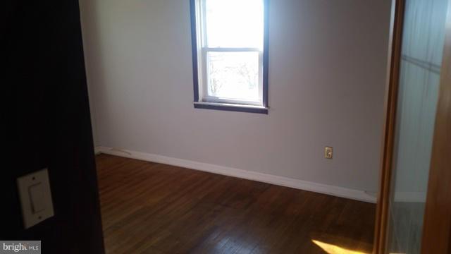 1215 Cedarcroft Road Baltimore, MD 21239 - Photo 4 of 11 an empty room with wooden floor and windows