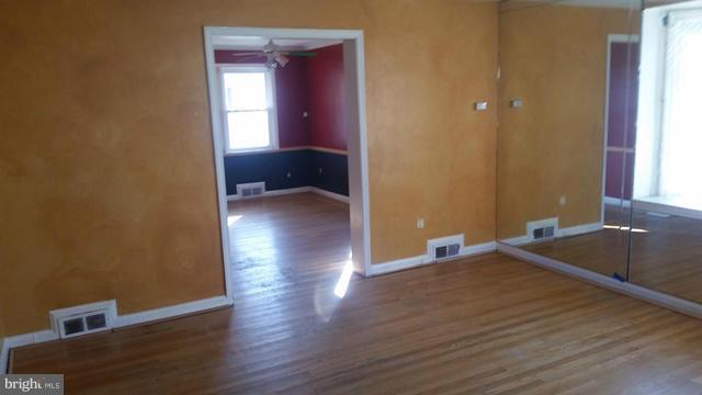 1215 Cedarcroft Road Baltimore, MD 21239 - Photo 8 of 11 a view of a room with wooden floor and windows