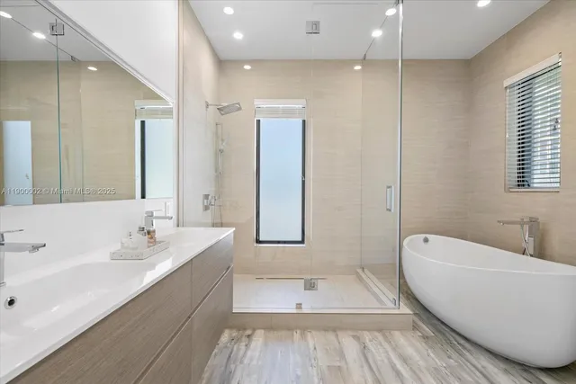 a spacious bathroom with a tub sink and mirror