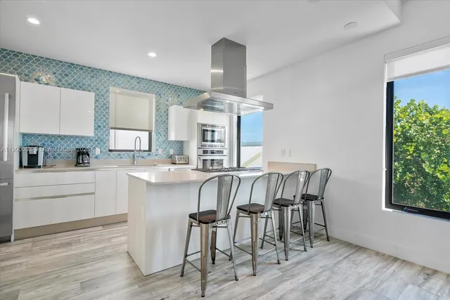 a kitchen with a table chairs refrigerator and window