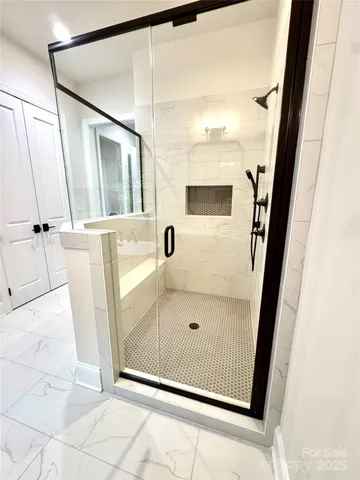 a bathroom with a glass door shower and vanity