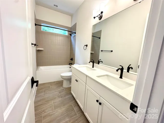 a bathroom with a sink a toilet and a large mirror