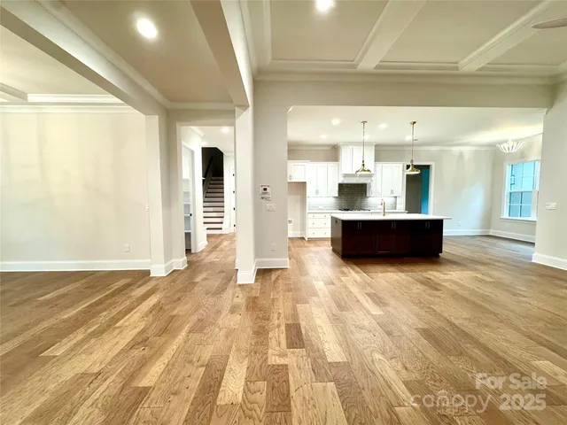 a view of a big room with wooden floor and windows