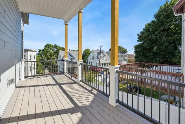 a view of a balcony with wooden floor and fence