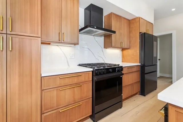a kitchen with stainless steel appliances granite countertop a refrigerator stove and cabinets