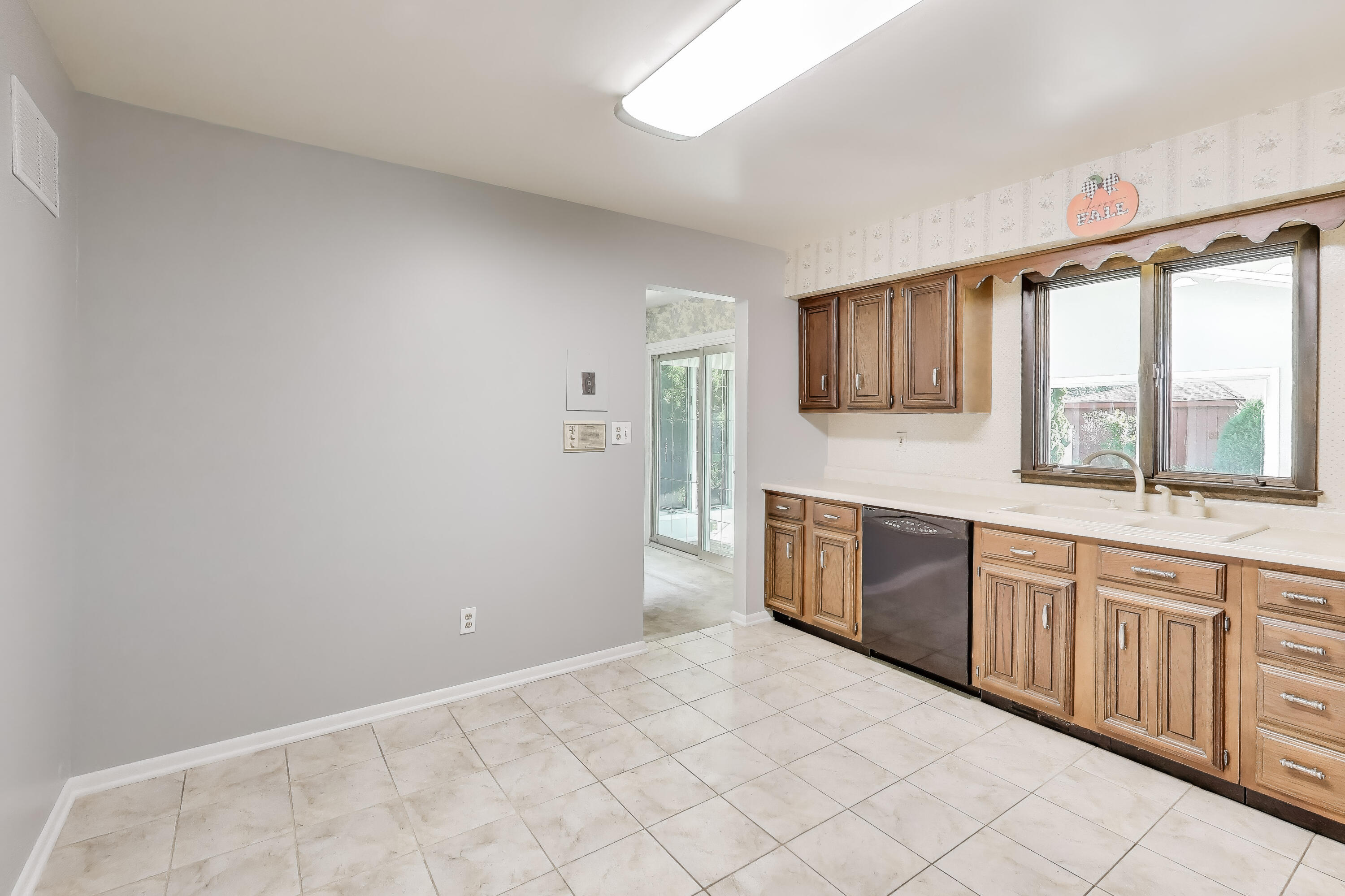 9449 Primrose Lane Munster, IN 46321 - Photo 9 of 34 a large white kitchen with a sink and dishwasher with a large window