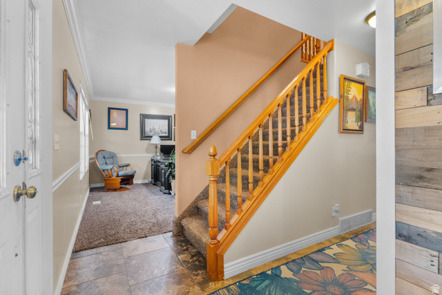 5727 South 3550th Street West Roy, UT 84067 - Photo 14 of 49 Entry/foyer featuring a wood-finish staircase with carpeted treads and a detailed balustrade
