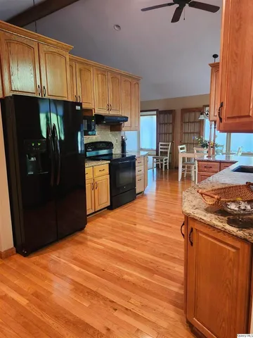 a kitchen with stainless steel appliances granite countertop a refrigerator a stove top oven a sink and dishwasher