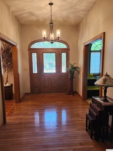 a view of a livingroom with a furniture wooden floor and chandelier