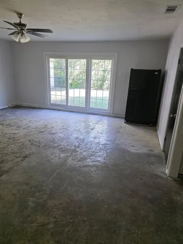 an empty room with windows and cabinet