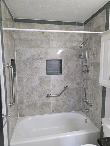 a bathroom with a shower and a bath tub