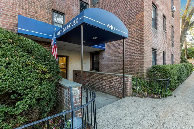 a view of an empty room with wooden floor and a cabinet
