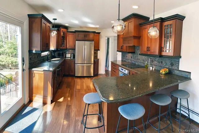 a kitchen with stainless steel appliances granite countertop a sink a stove and a refrigerator