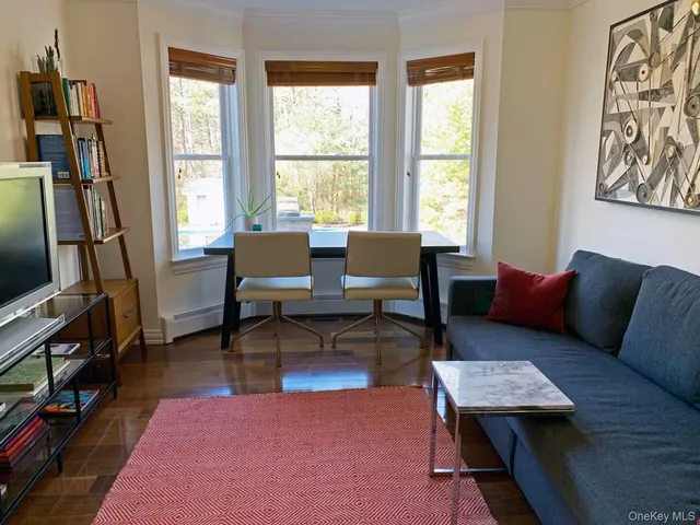 a living room with furniture a flat screen tv and a window