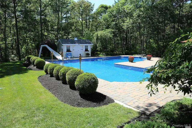 a view of a house with swimming pool and furniture