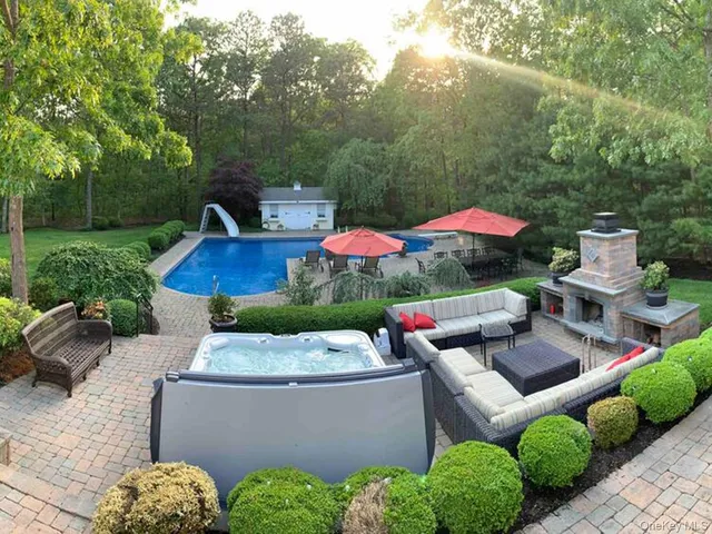 a front view of a house with swimming pool and yard