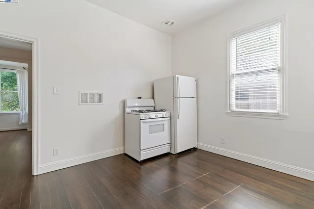 a view of kitchen with wooden floor and electronic appliances