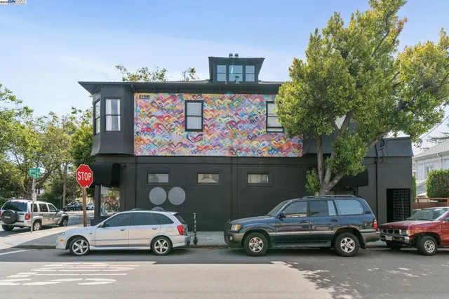 a front view of a building with cars parked