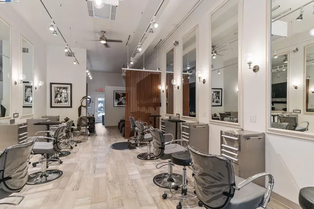a room with lots of white furniture and chandelier