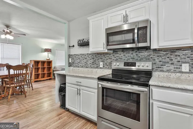 a kitchen with stainless steel appliances a stove microwave and cabinets