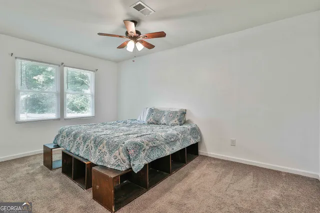 a bed sitting in a bedroom next to a window