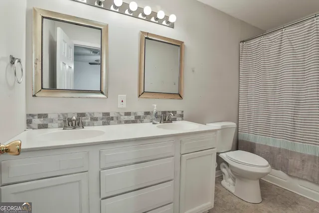 a bathroom with a toilet a sink a vanity and mirror