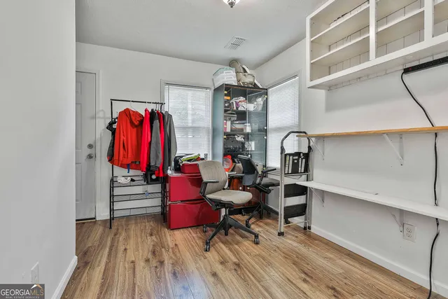 a view of a room with gym equipment and wooden floor