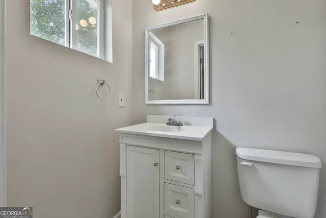 a bathroom with a toilet sink and mirror