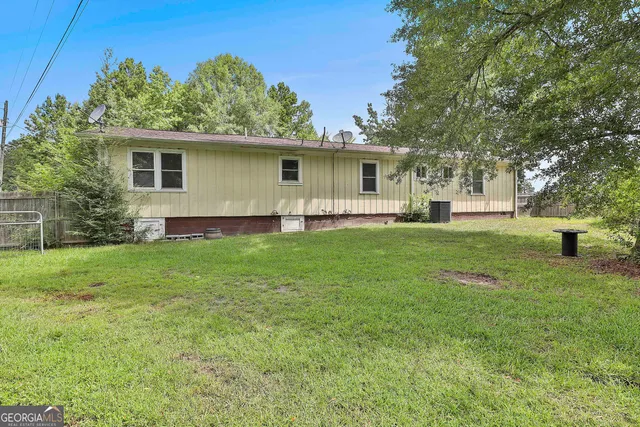 a view of a house with a big yard and sitting area