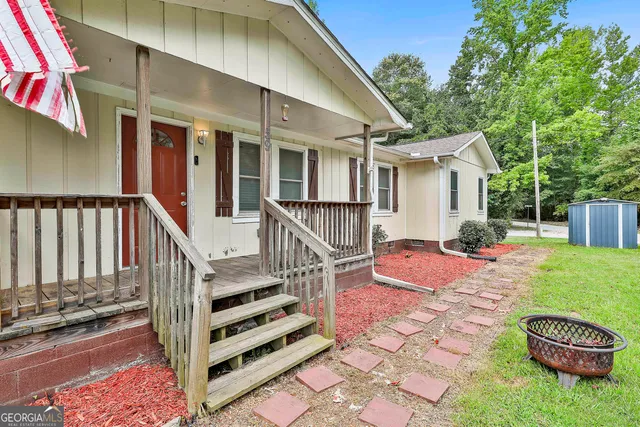 a backyard of a house with barbeque oven table and chairs