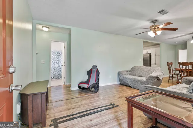 a living room with furniture a flat screen tv and a mirror