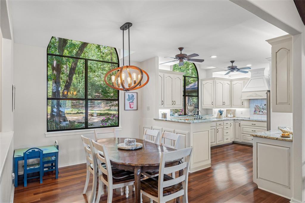 148 Pinewood Cove Holly Lake Ranch, TX 75765 - Photo 12 of 40 a kitchen with kitchen island granite countertop wooden floor cabinets and dining table