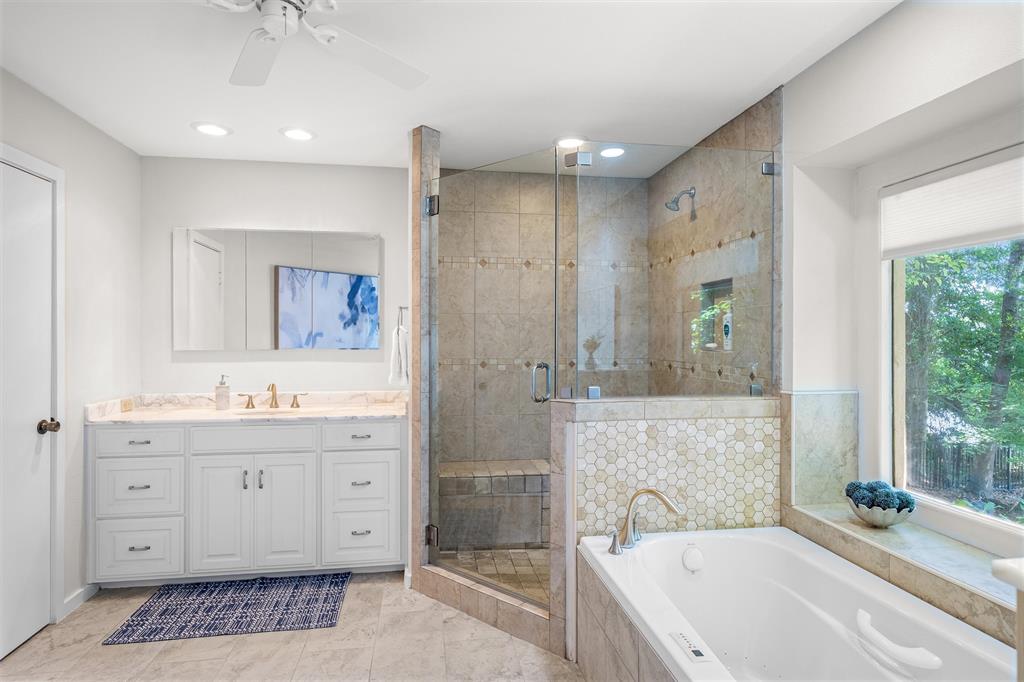 148 Pinewood Cove Holly Lake Ranch, TX 75765 - Photo 18 of 40 a spacious bathroom with a granite countertop tub sink a mirror a shower and vanity