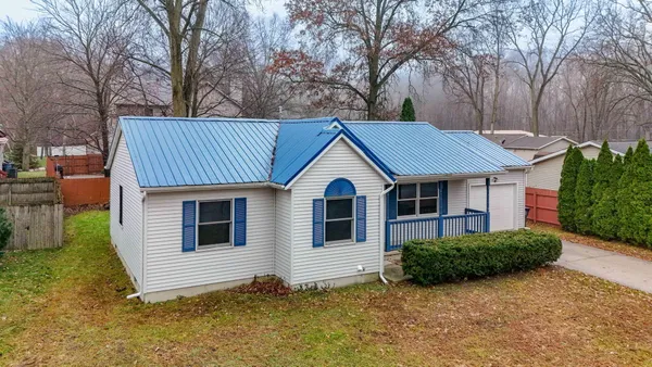 a view of a house with a yard and large tree and a yard