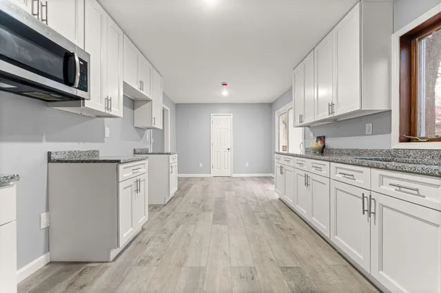 a kitchen with stainless steel appliances granite countertop a stove a sink and a microwave