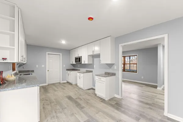 a open kitchen with white cabinets and white appliances
