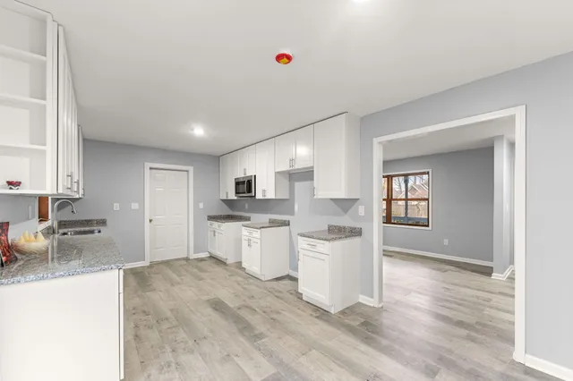 a open kitchen with white cabinets and white appliances