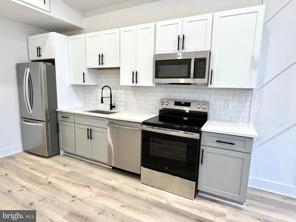 a kitchen with stainless steel appliances granite countertop a stove a microwave and a refrigerator