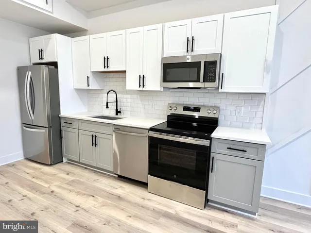 a kitchen with stainless steel appliances granite countertop a stove a microwave and a refrigerator