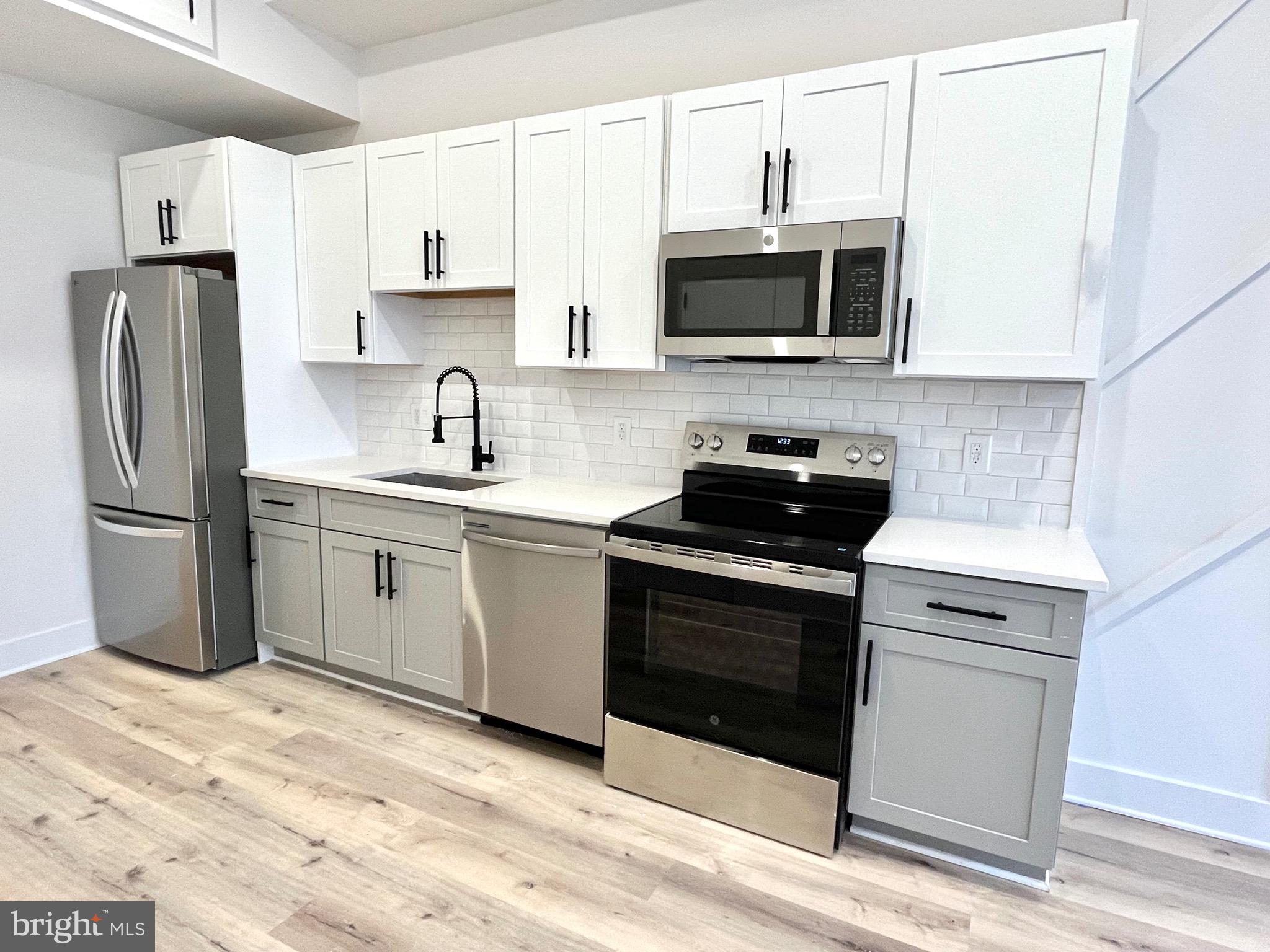 1802 11th Street Northwest, Unit 2A Washington, DC 20001 - Photo 5 of 15 a kitchen with stainless steel appliances granite countertop a stove a microwave and a refrigerator
