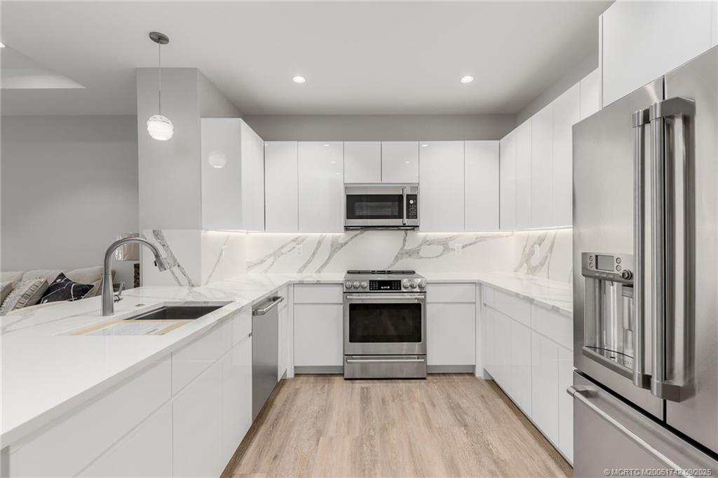 41 Southwest Seminole Street, Unit 305 Stuart, FL 34994 - Photo 11 of 50 a kitchen with a sink appliances and cabinets