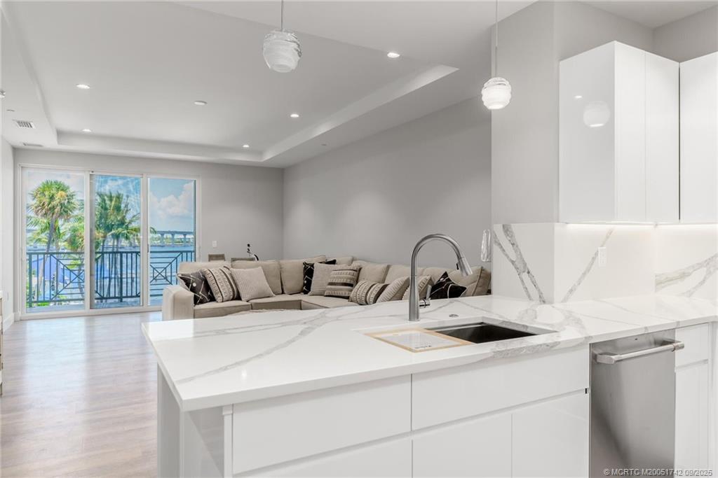 41 Southwest Seminole Street, Unit 305 Stuart, FL 34994 - Photo 13 of 50 a kitchen with a sink a large window and a rug