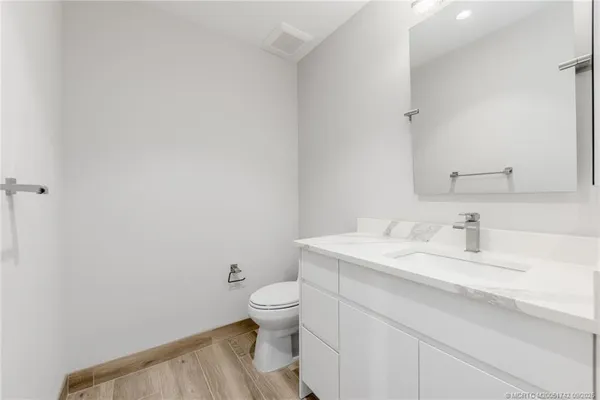 a bathroom with a granite countertop toilet and sink