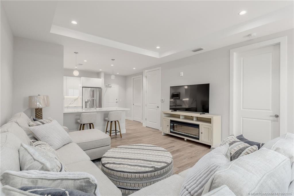 41 Southwest Seminole Street, Unit 305 Stuart, FL 34994 - Photo 9 of 50 a living room with furniture and a flat screen tv